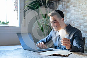 Crop close up of male employee work on computer hold bright light bulb get brilliant business idea. Businessman or worker feel