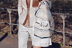 Crop couple in stylish outfits walking on street holding hands