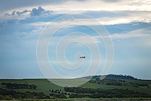 A crop duster flying on a sugar cane field