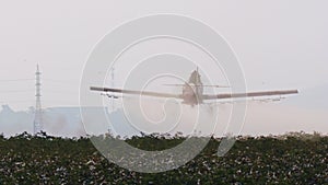 Crop duster spraying chemicals over a cotton field - slow motion