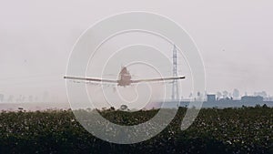 Crop duster spraying chemicals over a cotton field - slow motion