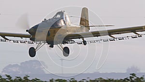 Crop duster spraying chemicals over a cotton field - slow motion