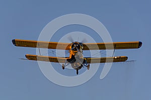 Crop duster spraying crops from the air in the morning light