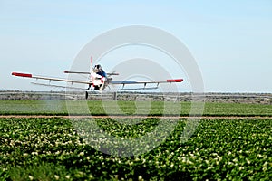 A crop dusting aircraft in action