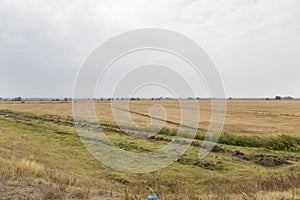 Water ditches irrigation system and a harvested grain field  photo