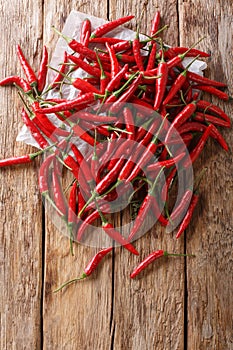 Crop of fresh hot chili piri-piri close-up on wooden. Vertical top view