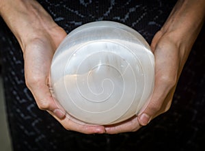 Crop hands holding selenite sphere photo