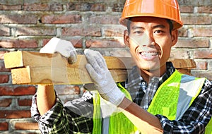 Crop images of man worker carrying wood smiling