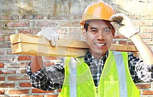 Crop images of man worker carrying wood smiling