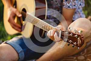 Crop of incognito male hand playing on guitar.