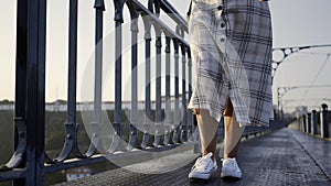 Crop legs walking on vintage bridge