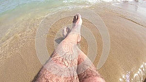 Crop of male legs on beach