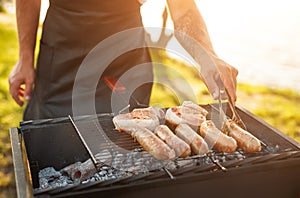 Crop man cooking meat in countryside