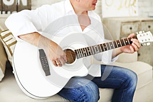 Crop man playing acoustic guitar