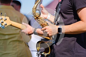 Crop man playing saxophone on street