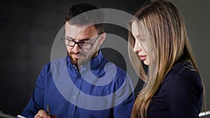 Crop office workers signing papers. Unrecognizable business man and woman standing and signing papers in office.