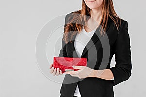 Crop photo of smiling women in black suit with red purse on gray