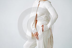 Crop photo of young blonde woman in sportswear on background of white wall