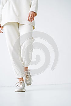 Crop photo of young woman in sportswear on background of white wall