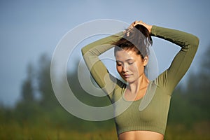 Pretty girl doing hair do in nature. photo