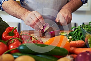 Crop shot of hands cutting an onion with a knife