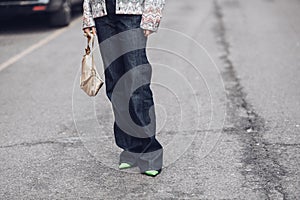 Crop stylish woman standing on street with handbag