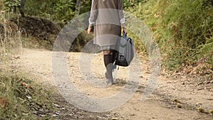 Crop view of atractive young universitarian woman with backpack walking in the woods,park