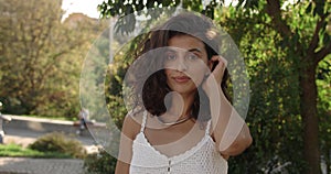 Crop view of attractive latino woman turning head and looking to camera. Portrait of beautiful female person smiling and