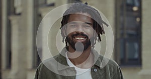 Crop view of handsome man with beard and moustache looking and posing to camera. Portrait of young guy with dreadlocks