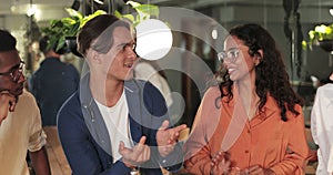 Crop view of joyful diverse friends having good time while sitting in modern cafe.Young good looking coworkers