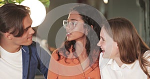 Crop view of young joyful friends laughing and having fun in cafe. Group of millennial cheerful people spending good