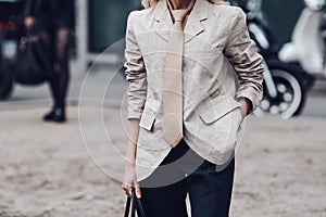 Crop woman in jacket and tie on street