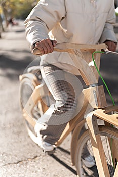 Crop woman riding wooden bike