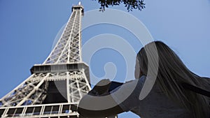 Crop woman taking photo of Eiffel tower