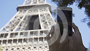 Crop woman taking photo of Eiffel tower