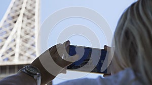 Crop woman taking picture of Eiffel Tower