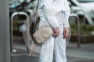 Crop woman in white outfit with handbag