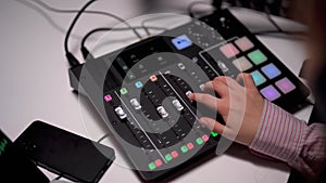 Crop of young woman operating a soundboard for podcast recording