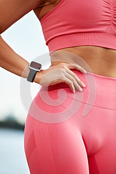 croped shot of young athletic woman working out in a park in an urban environment. Attractive athletic woman exercising