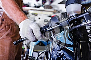 Croped view of man working in garage repairing motorcycle