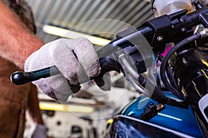 Croped view of man working in garage repairing motorcycle