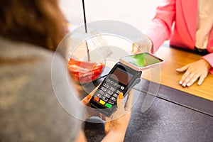 Croped young smiling fun happy woman wearing pink shirt hold wireless bank payment terminal to process acquire credit