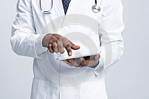 Cropped of african doctor using digital tablet