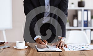 Cropped of african manager signing papers in office