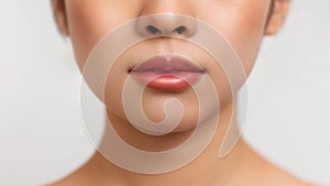 Cropped of asian lady showing her beautiful soft lips, posing over white studio background, closeup shot