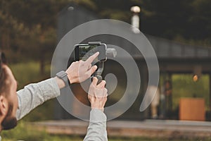 Cropped back view of businessman holding smartphone with steadycam