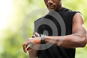 Cropped of black sportsman using his smartwatch