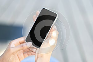 Cropped of black woman hands using smartphone, blurred outdoor background