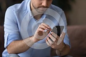 Cropped close up man using smartphone, typing on screen