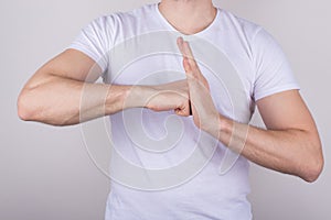 Cropped close up photo of serious confident guy giving punch to the palm showing his determination isolated over gray color